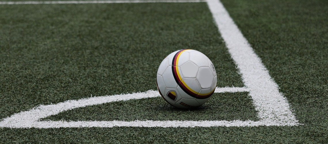 Fotball som står i korner-feltet på en fotballbane.