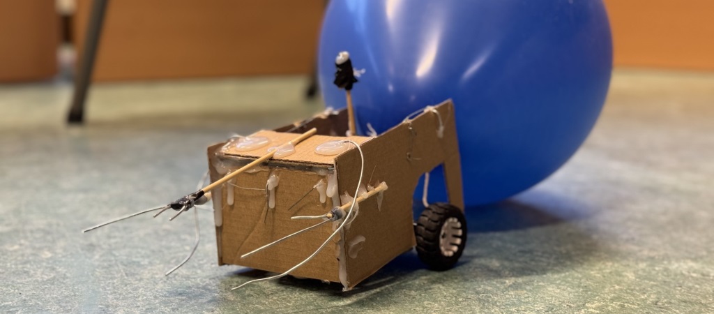 Bil av papp med ballong bak