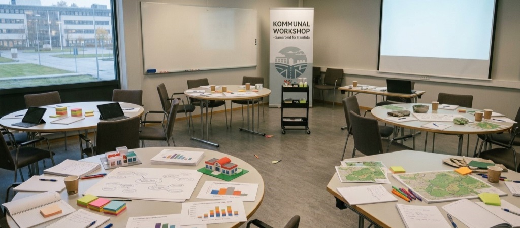 Bilde av flere rundbord i et konferanserom. Bildet er KI-generert ved hjelp av Google gemini.